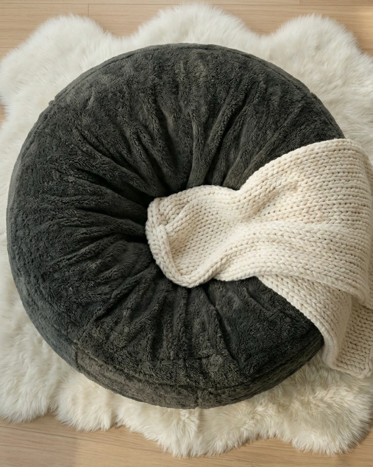 Overhead view of a charcoal Cosac with a cream knitted blanket, shown with a 5ft customer review in Cosac’s gallery