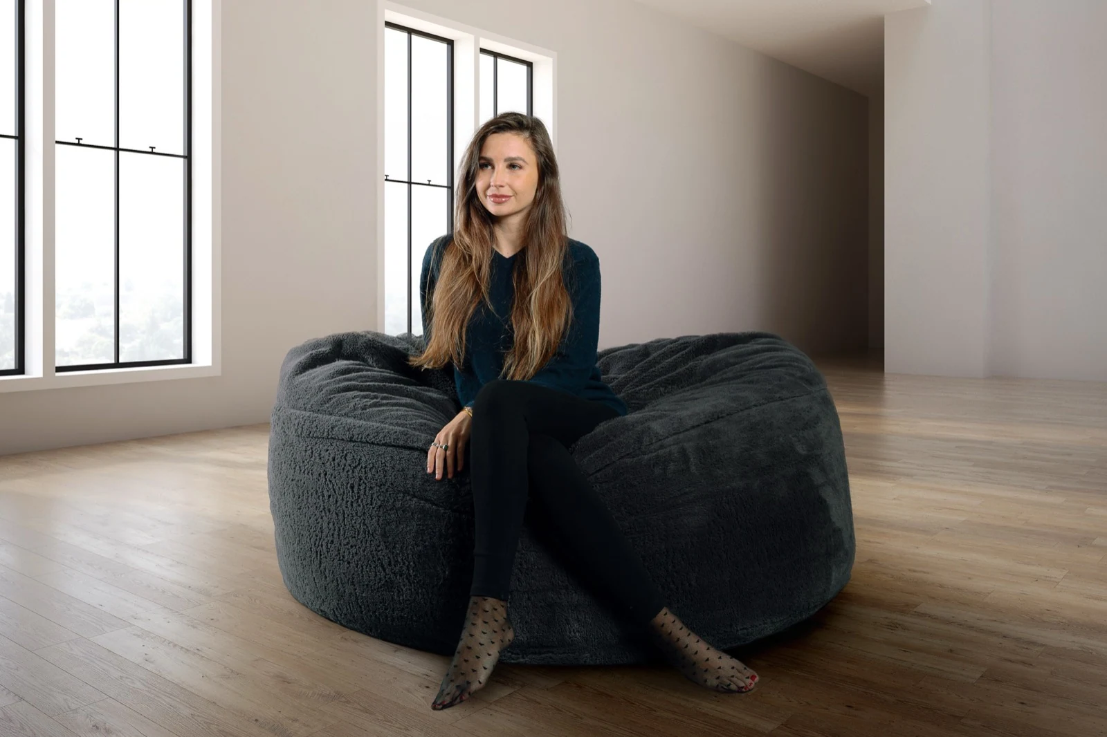A person seated in a charcoal Cosac 5ft beanbag, with the complete chair visible