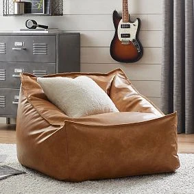 Pottery Barn Teen Caramel Modern Lounger styled with a decorative pillow; pictured size not specified